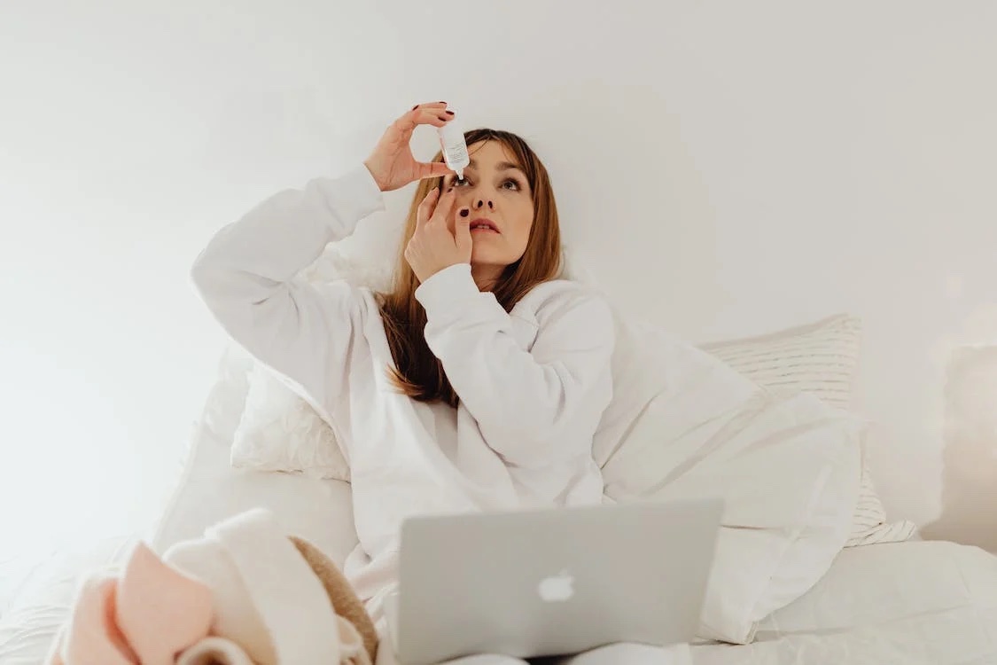 woman putting in eye drops
